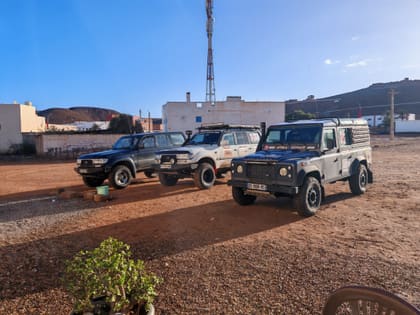 Three four-wheel drives on red earth, ready for the track