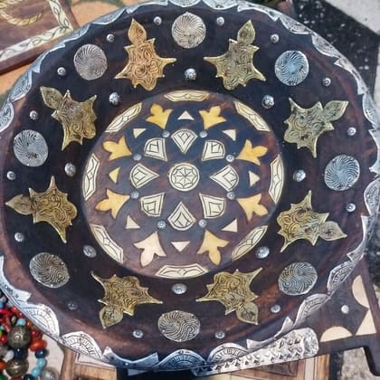 A wooden bowl inlaid with brass, silver and camel bone