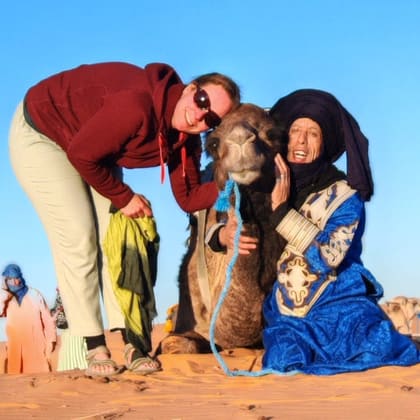 Isabelle and Ali with a camel in the dunes